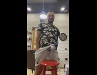 Guy picks up dumbbell through grey shorts