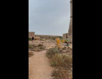 Woman in yellow dress that is blown by the strong wind