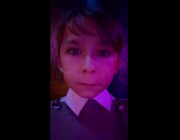 Small man stares at camera inside bar