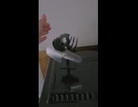 Person spin two fans over portable fireplace