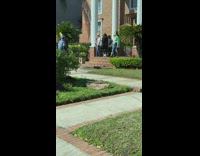 Women pose for photo brick building