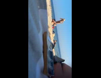 Man on sand takes picture of woman