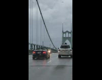 Guy standing through sunroof photographs black car 