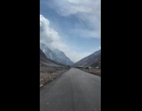 Person drive pass by camp between mountains