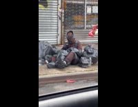 Person sits on street trash man costume