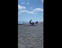 Two girls film themselves dancing at beach