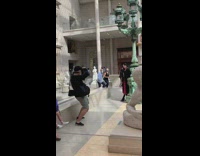 Woman black coat lamp post statue museum