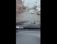 Filmer drive car pass by flooded street.