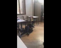 girl in black puts her leg up to her friends head and falls down 