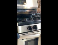 Small grey mouse rat hiding behind black cast iron pan