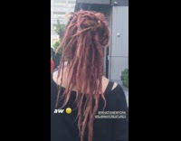 Pet owner and dog have matching dreadlock hair 