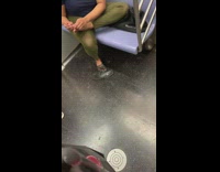 Woman green leggings takes off shoes and picks foot on subway train