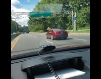 Wood planks stick out red car window 