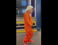 Person wears trump mask and orange clothes 