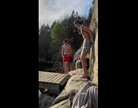 Guy with backwards hat jumps off dock in lake