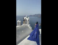 Girl long blue dress on roof Santorini