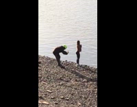 Girl poses by river neon green helmet 