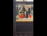 Man play trumpet hit orange buckets subway