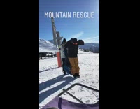 Two guys lift friend blue jacket upside down on skis and walk on snow slope