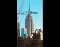 People walk on tall construction crane in skyline